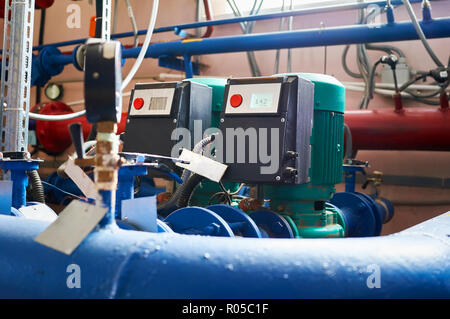 Blue pump motor and the inverter connected to the pipes blue. Stock Photo