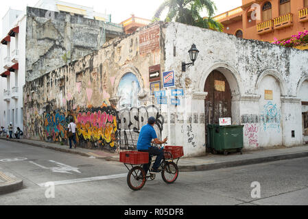 Delivery man on bike holding his mobile phone in hand. Daily life in Getsemani in Cartagena de Indias, Colombia. Oct 2018 Stock Photo
