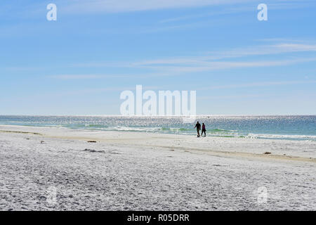 People walking along secluded and empty Florida panhandle beach at Deer Lake State Park, Florida USA. Stock Photo