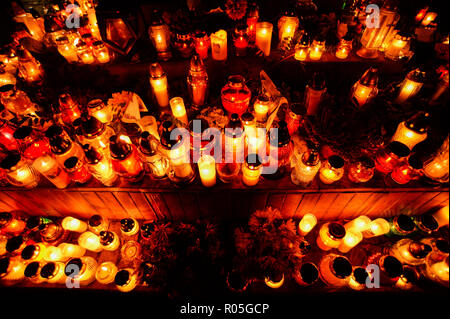 Candles are seen lighting on top of a grave at the Rakowicki Cemetery during the celebrations. All Saints Day, also known as The Day of the Dead, is a Roman Catholic day of remembrance of friends and loved ones who have passed away. Stock Photo