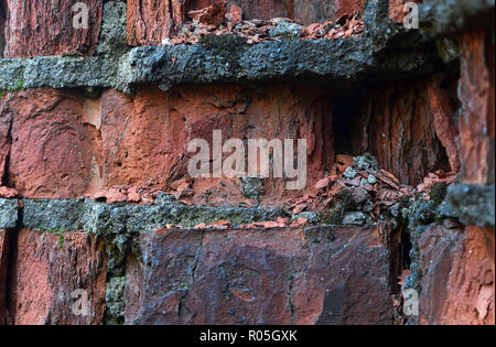 An old wall of collapsed, cracked, crumbling red brick. Red brick texture background Stock Photo