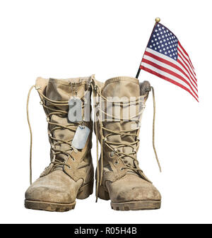 Old military combat boots with the American flag and dog tags, isolated on white background. Memorial Day or Veterans day concept. Stock Photo