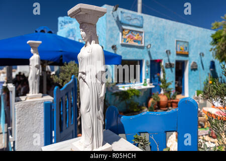 SANTORINI, GREECE - AUGUST 2018: Greek antique sculptures are staying at entrance of traditional village at Oia town Stock Photo