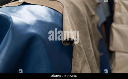 Different pieces of leather. The pieces of the colored leathers. Natural blue ang light brown leather. Raw materials for manufacture of bags, shoes, clothing and accessories. Stock Photo