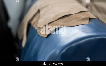 Different pieces of leather. The pieces of the colored leathers. Natural blue ang light brown leather. Raw materials for manufacture of bags, shoes, clothing and accessories. Stock Photo
