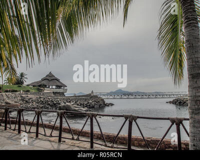 awesome view of a bay with a terrace on rocks a bridge with the sea in the background in Manzanillo Colima Mexico Stock Photo