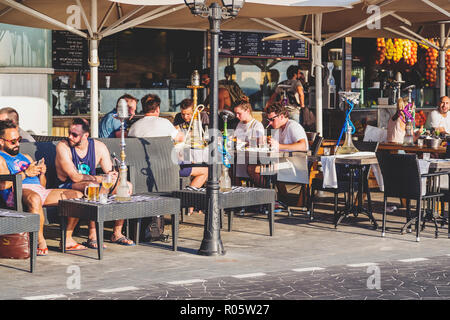 Tel Aviv-Yafo, Israel - June 6, 2018: View from the beach promenade of Tel Aviv with hotel buildings, residences and people walking around and eating  Stock Photo