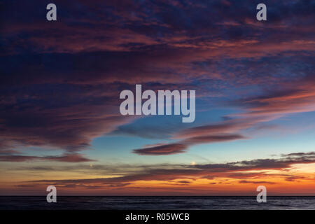 Dramatic colored sky. Moon and star in the clouds. Stock Photo