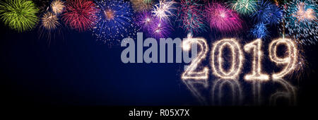 colorful fireworks and bright sparkler pyrotechnic number 2019 happy new year sylvester concept on black blue panorama background Stock Photo