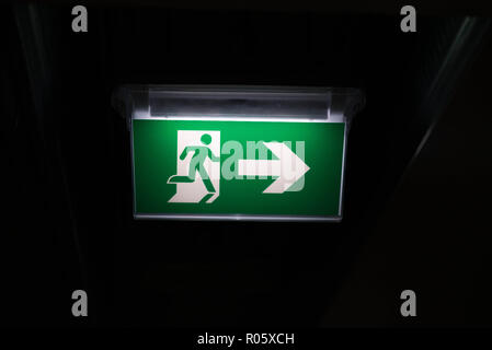 Emergency exit sign in dark parking garage Stock Photo