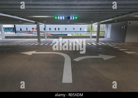 Arrows on the ground of a parking garage indicating which side to turn to. Stock Photo