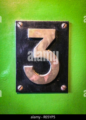 number 3 sign, number three metal sign on green background Stock Photo