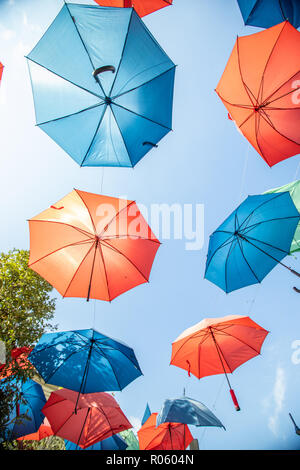 Colored umbrellas on the blue sky background on the street Stock Photo