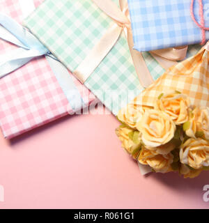 Check pattern colorful gift boxes with flower bouquet on pink background Stock Photo