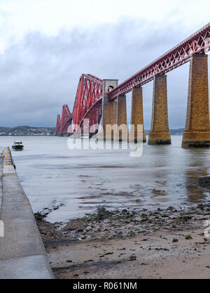 Vertical low view of Forth Bridge from viewed from South Queensferry on stormy day, Queens Ferry, Scotland, UK Stock Photo