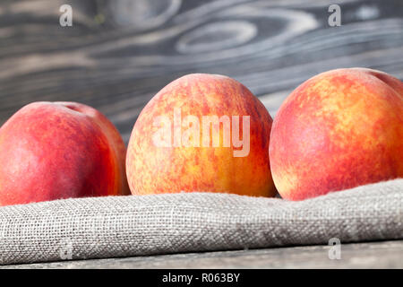 a bunch of ripe large peaches, fruits are in a linen tablecloth Stock Photo