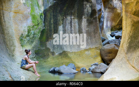 Adult caucasian female sitting down in the Tunnel. Drakensberg Ukhahlamba National Park, Kwazulu Natal Province, South Africa Stock Photo