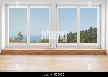 inside modern apartment with with wooden floor, terrace windows and panoramic landscape view Stock Photo