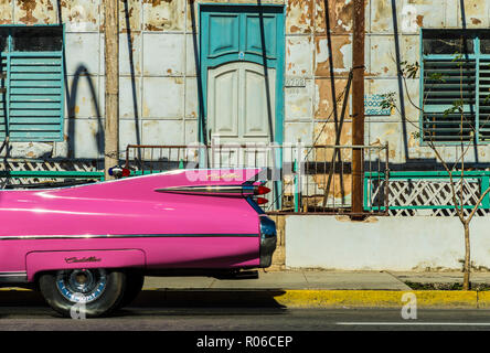 A classic American car driving past an old building in Varadero, Cuba, West Indies, Caribbean, Central America Stock Photo