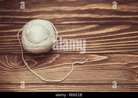 top view of blue woolen tangles of threads on wooden knitting background. Stock Photo