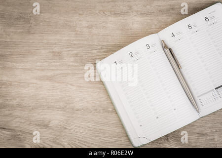 Blank notebook with pen and smartphone on wooden table, business concept Stock Photo