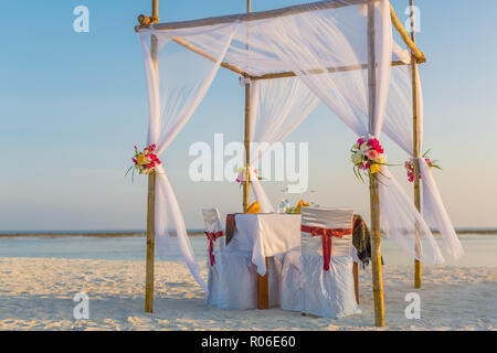 Wedding set up on the beach (vintage colour picture style). Beautiful bridal bouquet of white roses and orchids on a background of the sea. Stock Photo