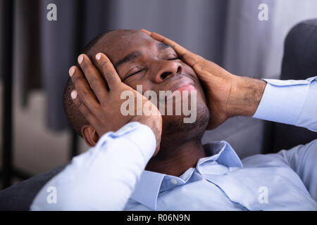 Close-up Of A Stressed Young Man With Hand On His Face Stock Photo