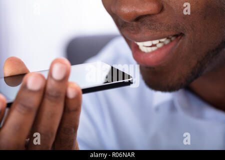 Close-up Of An African Man Using Voice Assistant On Cellphone Stock Photo