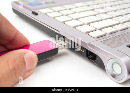 USB Pink flash drive stick being connected to computer, selective focus Stock Photo