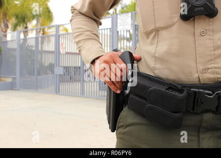 School safety concept - armed police officer on duty protecting closed campus high school in California