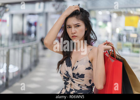stressed young woman with shopping bags in mall Stock Photo