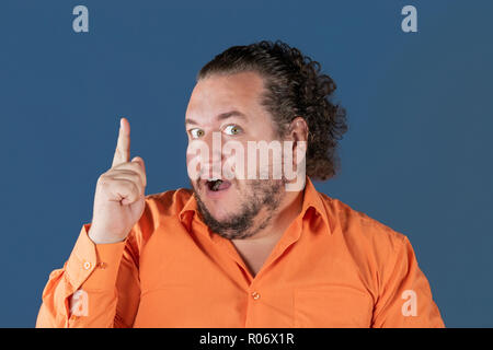 Fat man in orange shirt holding his thumb up Stock Photo