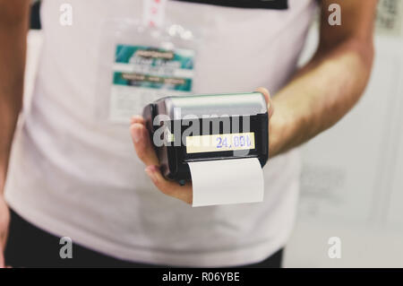 Caucasian seller man holding card machine or POS terminal in his hands Stock Photo