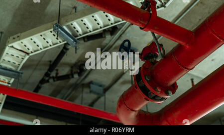 Fire sprinkler system with red pipes hanging from ceiling inside building. Fire Suppression. Fire protection and detector. Main supply water piping in Stock Photo