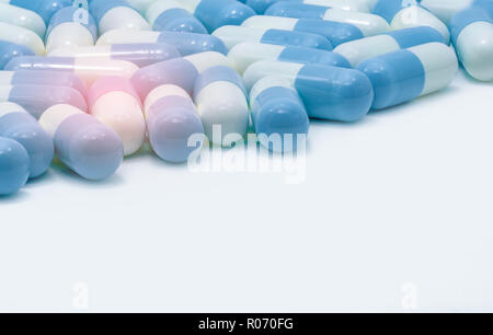 Blue-white pastel color capsule pills on white background. Global healthcare. Pharmaceutical industry. Pharmacy background. Antibiotic drug resistance Stock Photo