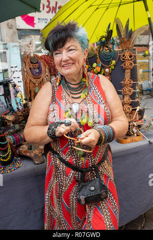 Posed portrait of an older Israeli woman with blue hair who sells leather jewelry at the Carmel Market in Tel Aviv, Israel. Stock Photo