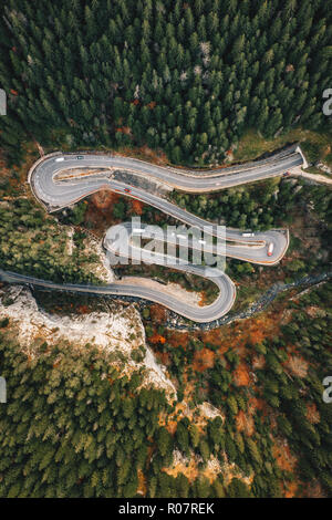 Top-down view of an extreme curved winding road in the middle of a forest Stock Photo