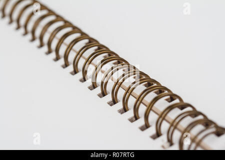 side perspective view closeup of open notebook with copper metal spirals and blank white pages Stock Photo
