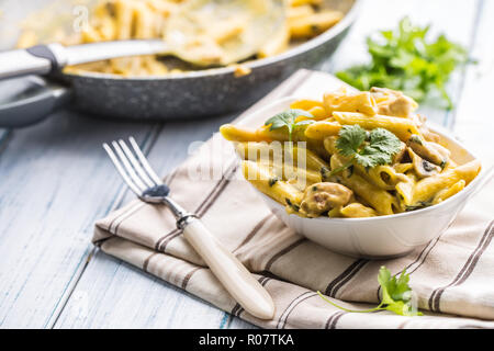 Pasta pene with chicken pieces mushrooms parmesan cheese sauce and herb decoration. Pene con pollo - Italian or medierranean cuisine.