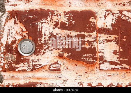 Fragment of old brick walls covered with red paint and with metal rods as bonding Stock Photo