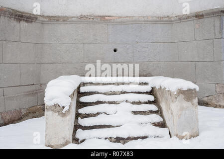 Snow-covered stone staircase near wall of old grey building with Stock Photo