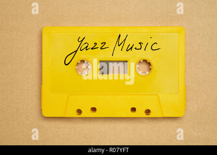 Retro yellow audio cassette tape with jazz music laying on the paper background Stock Photo