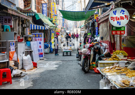 A view along a busy alley lined with stalls in the indoor market, Bupyeong Khangtong Market in Busan, South Korea. Stock Photo