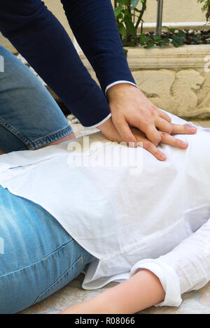 Man doing cardiopulmonary resuscitation to a woman. Stock Photo