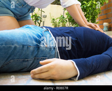 Woman doing cardiopulmonary resuscitation to a man. Stock Photo