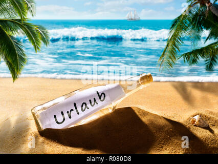 Bottle with the message Holiday on a beautiful tropical beach Stock Photo