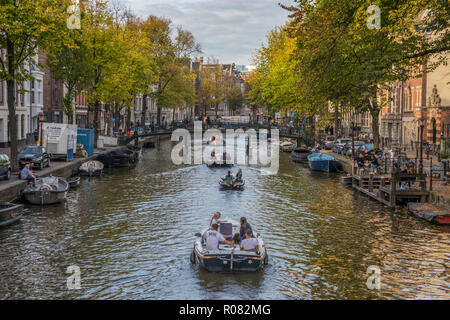 Boats with tourist sailing in Amsterdam canal Stock Photo