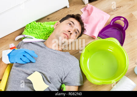 Young husband in crisis housework. Close up of stressed man with cleaning equipment Stock Photo