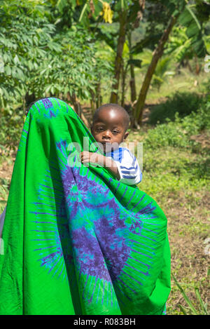 mother with headscarf  carries child on arm in Kenya, Africa Stock Photo