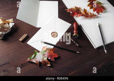Vintage stationery template and autumn leaves on wood table background. Responsive design mockup. Stock Photo